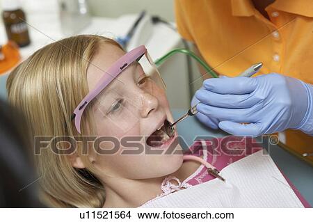 Picture - Girl (7-10) having teeth examined at dentists, (close-up). Fotosearch