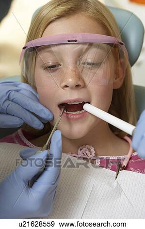 Girl (7-10) having teeth examined at dentists, (close-up) View Large Photo Image Stock Photo - Girl (7-10) having teeth examined at dentists, (close-up). Fotosearch