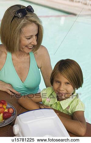 Stock Photography - Girl (7-9) with grandmother at pool, portrait.. Fotosearch