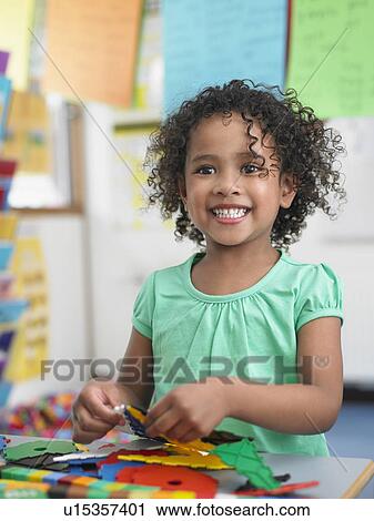 Girl assembling puzzles in classroom, portrait View Large Photo Image Stock Image - Girl assembling puzzles in classroom, portrait. Fotosearch