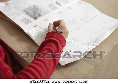 Girl doing homework on table, close up of hand on exercise book View Large Photo Image Stock Image - Girl doing homework on table, close up of hand on exercise book. Fotosearch