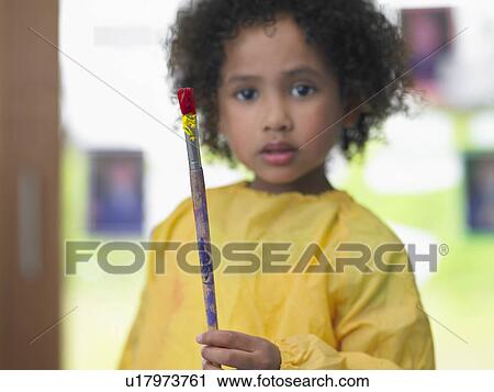 Girl holding paint brush in art class, portrait View Large Photo Image Stock Image - Girl holding paint brush in art class, portrait. Fotosearch