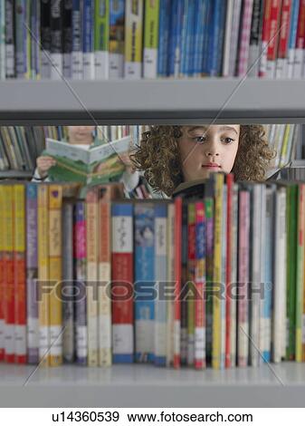 Girl selecting books from library bookshelf View Large Photo Image Stock Photo - Girl selecting books from library bookshelf. Fotosearch