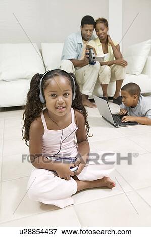 Girl sitting on living room floor Listening to Music on Portable CD Player, portrait View Large Photo Image Stock Photo - Girl sitting on living room floor Listening to Music on Portable CD Player, portrait. Fotosearch