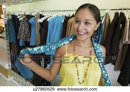 Stock Photo - Girl Trying on Sequin Boa in clothing store. Fotosearch