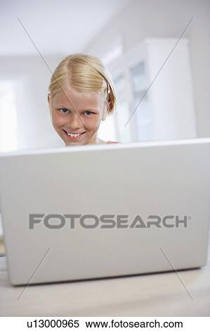 Girl using laptop on table at home, portrait View Large Photo Image Stock Photography - Girl using laptop on table at home, portrait. Fotosearch