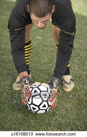 Goalkeeper bending down with ball, portrait View Large Photo Image Stock Image - Goalkeeper bending down with ball, portrait. Fotosearch