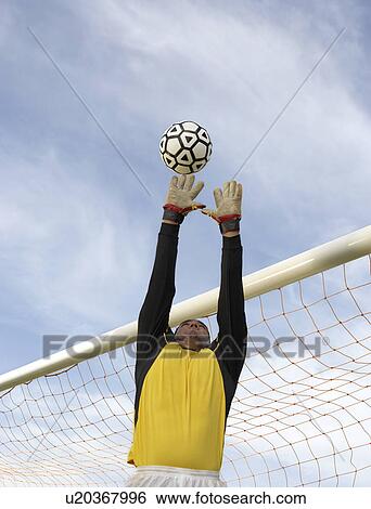 Stock Photograph - Goalkeeper reaching for ball. Fotosearch