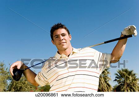 Golfer holding club on shoulders, (portrait), (low angle view) View Large Photo Image Stock Image - Golfer holding club on shoulders, (portrait), (low angle view). Fotosearch