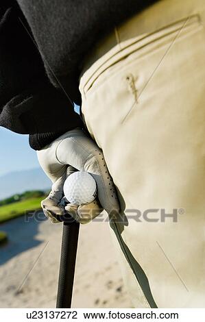 Golfer holding golf ball and club, (close-up) View Large Photo Image Stock Image - Golfer holding golf ball and club, (close-up). Fotosearch