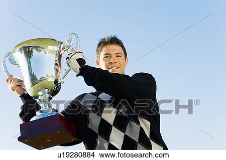 Golfer holding trophy, (portrait) View Large Photo Image Picture - Golfer holding trophy, (portrait). Fotosearch