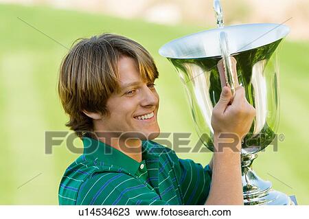 Golfer holding trophy View Large Photo Image Stock Image - Golfer holding trophy. Fotosearch