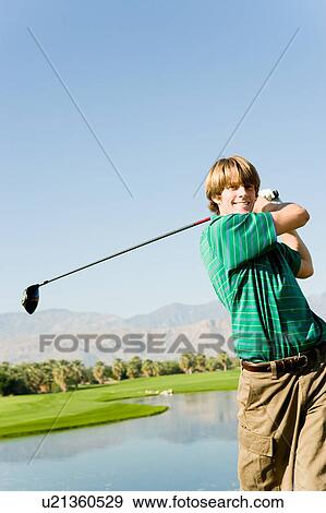 Golfer swinging club View Large Photo Image Stock Photo - Golfer swinging club. Fotosearch