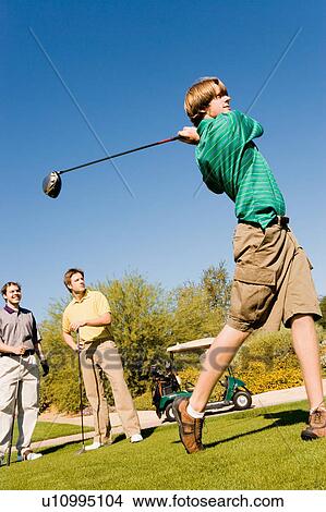 Golfer teeing off View Large Photo Image Picture - Golfer teeing off. Fotosearch