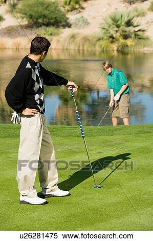 Stock Photography - Golfer watching other golfer play. Fotosearch