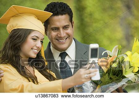 Graduate and father taking picture with cell phone outside View Large Photo Image Stock Image - Graduate and father taking picture with cell phone outside. Fotosearch