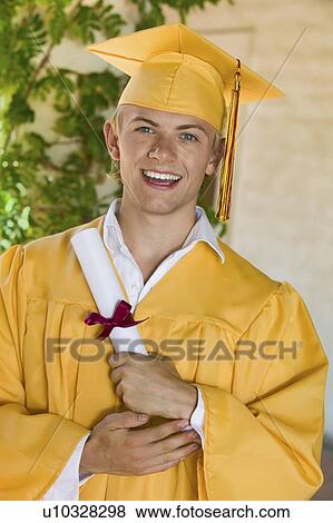 Graduate holding diploma outside, portrait View Large Photo Image Stock Photo - Graduate holding diploma outside, portrait. Fotosearch