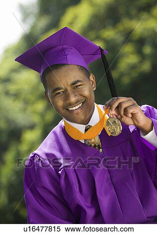Stock Photography - Graduate Holding Medal outside, portrait. Fotosearch