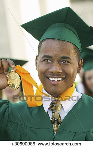 Stock Photograph - Graduate Holding Medal outside. Fotosearch
