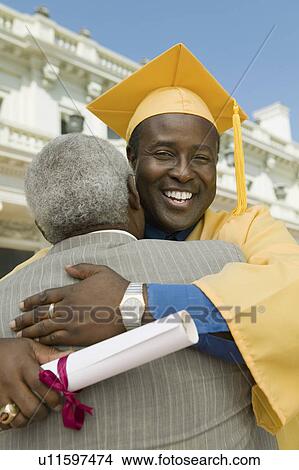 Graduate hugging father outside university View Large Photo Image Picture - Graduate hugging father outside university. Fotosearch