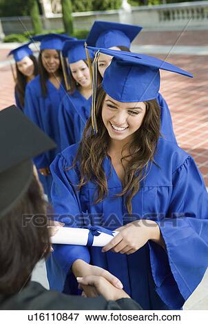 Stock Photo - Graduate shaking hand of dean outside, elevated view. Fotosearch