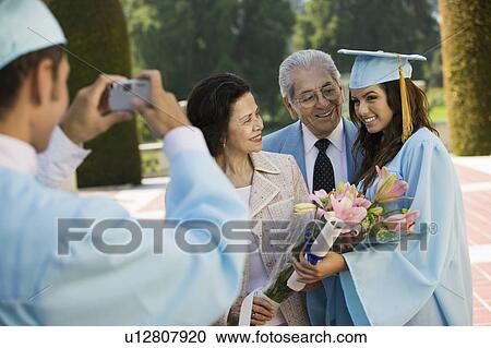 Graduate taking picture of other graduate and grandparents outside View Large Photo Image Stock Image - Graduate taking picture of other graduate and grandparents outside. Fotosearch