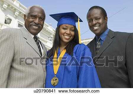 Stock Image - Graduate with father and grandfather outside university, low angle view, portrait. Fotosearch