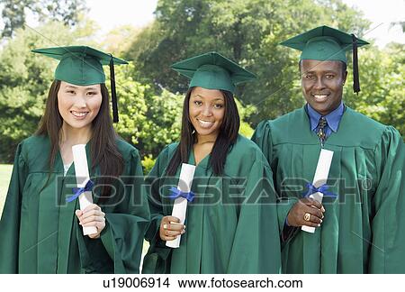Graduates hoisting diplomas outside university, portrait View Large Photo Image Picture - Graduates hoisting diplomas outside university, portrait. Fotosearch