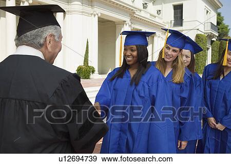 Graduates in line to shake hand of dean outside university View Large Photo Image Stock Photo - Graduates in line to shake hand of dean outside university. Fotosearch