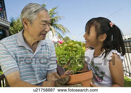 Stock Photo - Grandfather and granddaughter gardening. Fotosearch