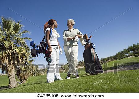 Grandmother and granddaughter on golf course, smiling View Large Photo Image Stock Photo - Grandmother and granddaughter on golf course, smiling. Fotosearch