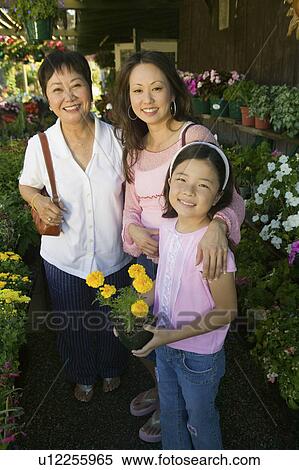 Stock Photography - Grandmother, mother and daughter Shopping for Plants in nursery, portrait. Fotosearch
