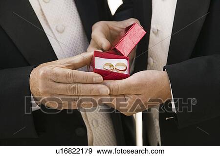 Groom and father holding wedding rings, (close-up) View Large Photo Image Stock Photo - Groom and father holding wedding rings, (close-up). Fotosearch