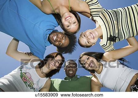 Stock Photo - Group of friends in circle, view from below, portrait. Fotosearch