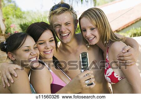 Stock Photograph - Group of friends photographing selves with camera phone. Fotosearch