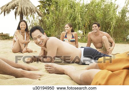 Stock Image - Group of Friends talking on the Beach. Fotosearch