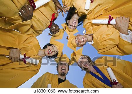 Group of graduates holding diplomas outside, view from below View Large Photo Image Stock Image - Group of graduates holding diplomas outside, view from below. Fotosearch