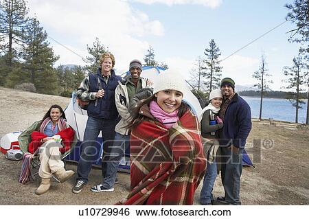 Stock Photograph - Group of young adults outdoors at campsite, front view.. Fotosearch