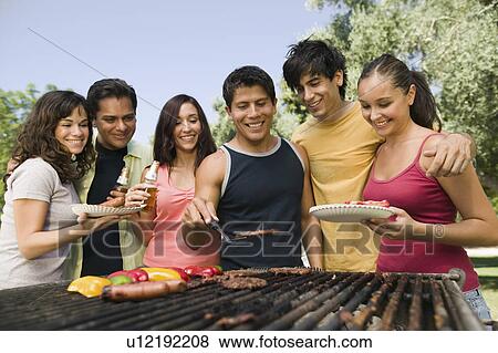 Stock Photo - Group of young people around outdoor grill.. Fotosearch