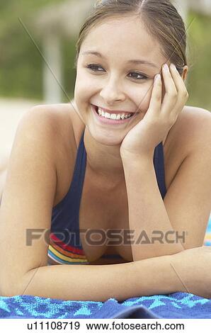Stock Photo - Happy Young Woman lying down on Beach, smiling, close-up. Fotosearch