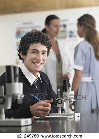 Stock Image - High school student sitting at desk in chemistry class, portrait. Fotosearch
