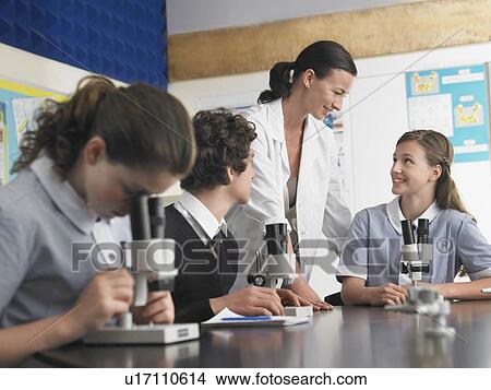High school students talking with teacher in chemistry class View Large Photo Image Picture - High school students talking with teacher in chemistry class. Fotosearch