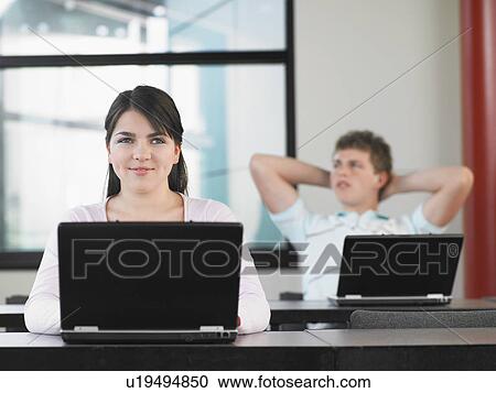 Stock Image - High school students using laptops in classroom. Fotosearch