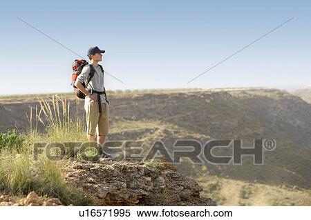 Stock Photography - Hiker standing on top of mountain. Fotosearch