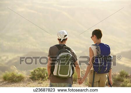 Hiking couple standing on top of mountain, back view View Large Photo Image Stock Image - Hiking couple standing on top of mountain, back view. Fotosearch