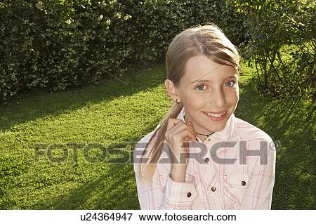 Stock Photo - Little Girl Standing in back yard, portrait. Fotosearch