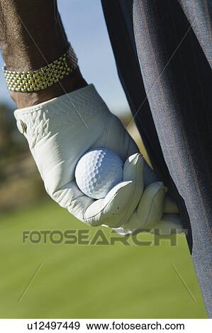 Male golfer holding golf ball, close-up of hand, (close-up) View Large Photo Image Stock Photo - Male golfer holding golf ball, close-up of hand, (close-up). Fotosearch