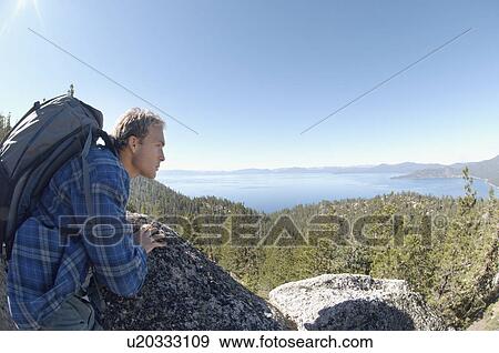 Stock Photo - Male hiker looking at view from mountain. Fotosearch