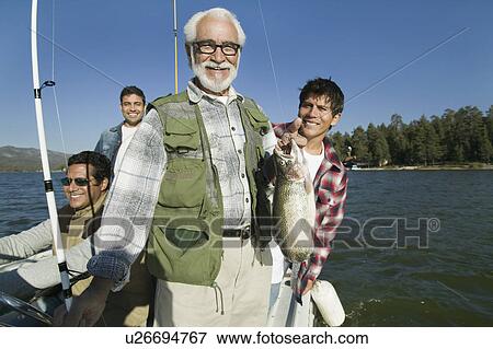 Male members of three generation family on fishing boat, man holding fish View Large Photo Image Stock Photo - Male members of three generation family on fishing boat, man holding fish. Fotosearch