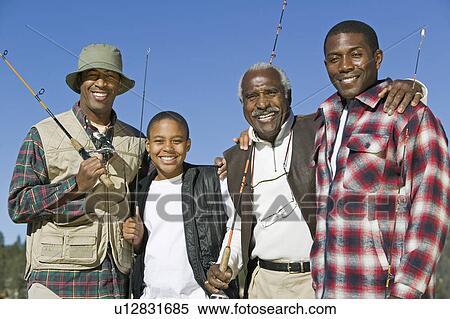 Stock Photography - Male members of three generation family holding fishing rods outdoors, smiling, (portrait). Fotosearch
